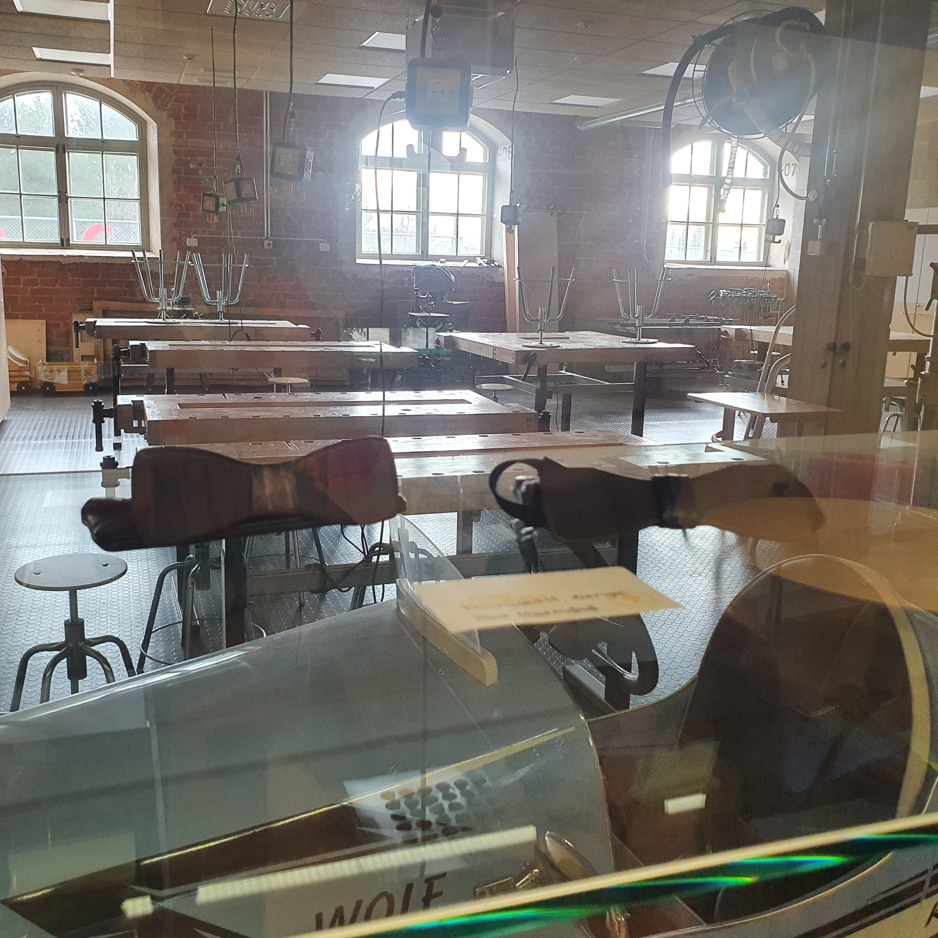Looking through a glass display case into the wood workshop