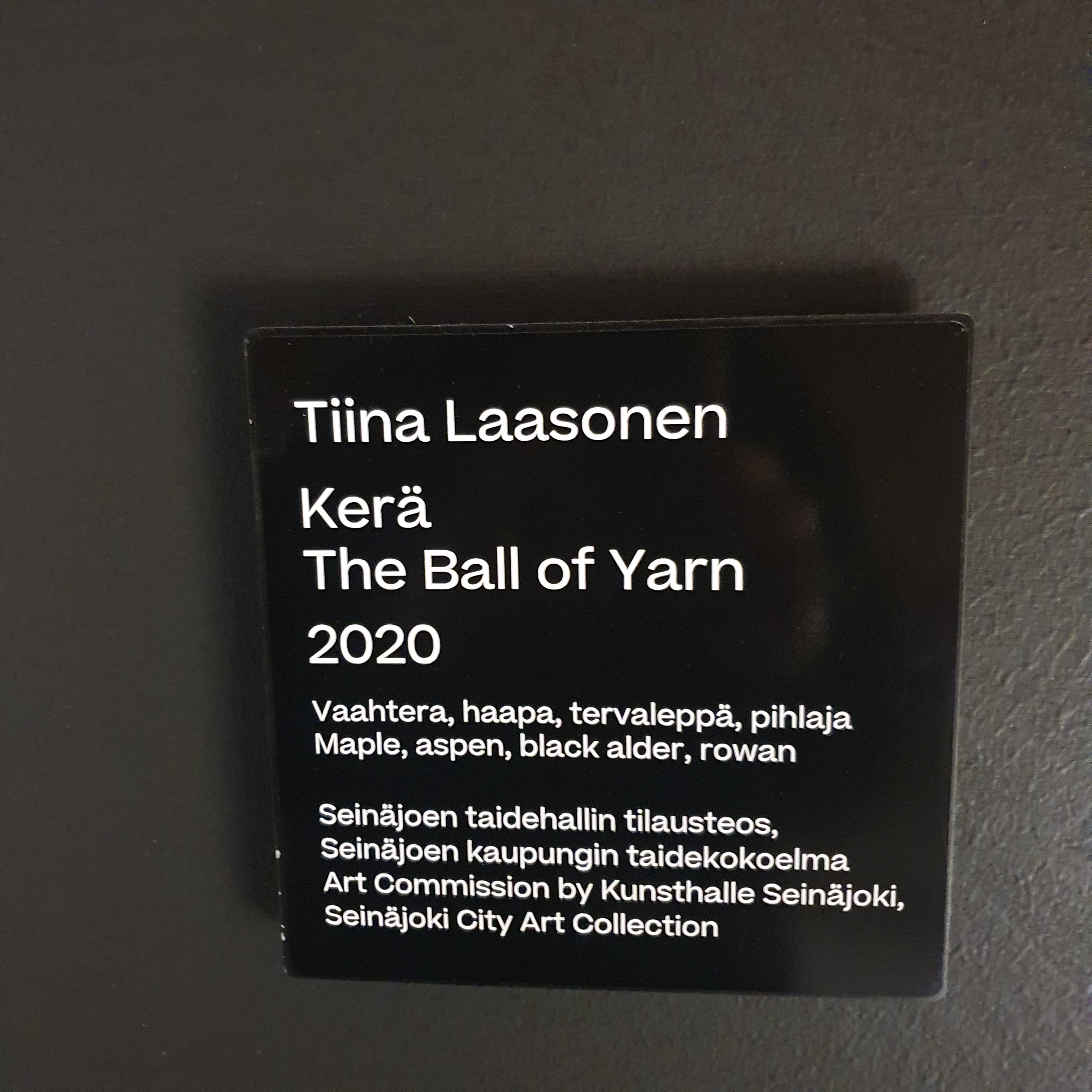 Sign on the wall that reads "Tiina Laasonen, Kerä, The Ball of Yarn, 2020, Maple, Aspen, Black alder, Rowan."