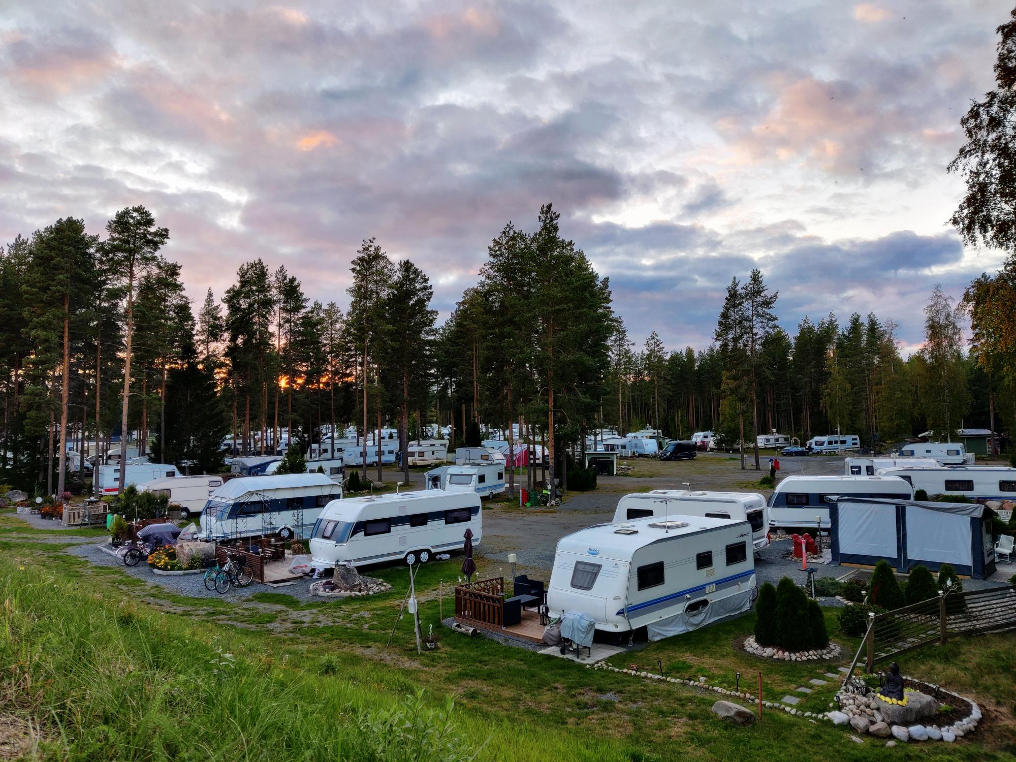 A view over SF-Caravan-Kalajärvi with purple-grey clouds and red light from the sun on the horizon