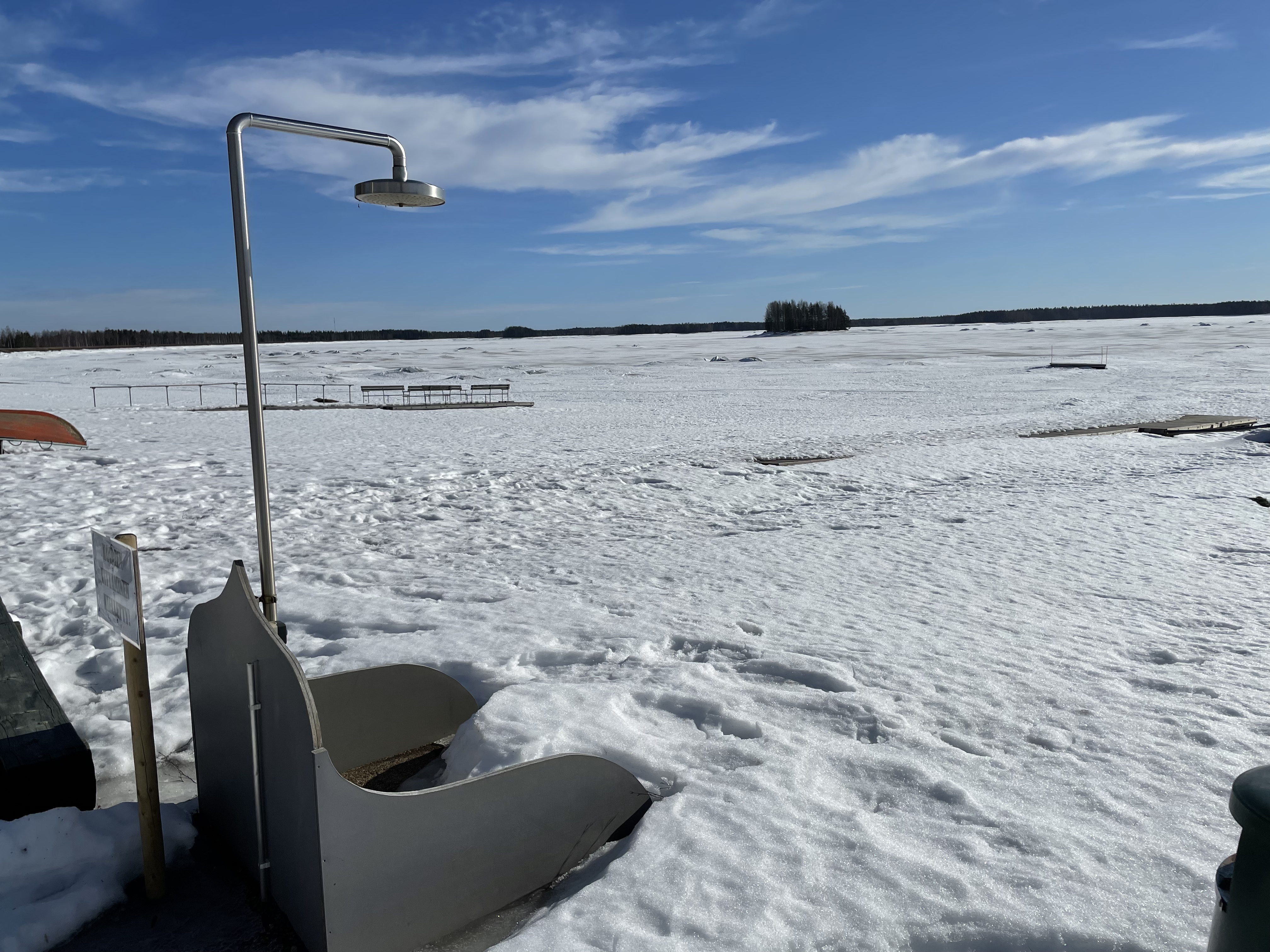 A frozen lake Kalajärvi with a lakeside shower in the foreground