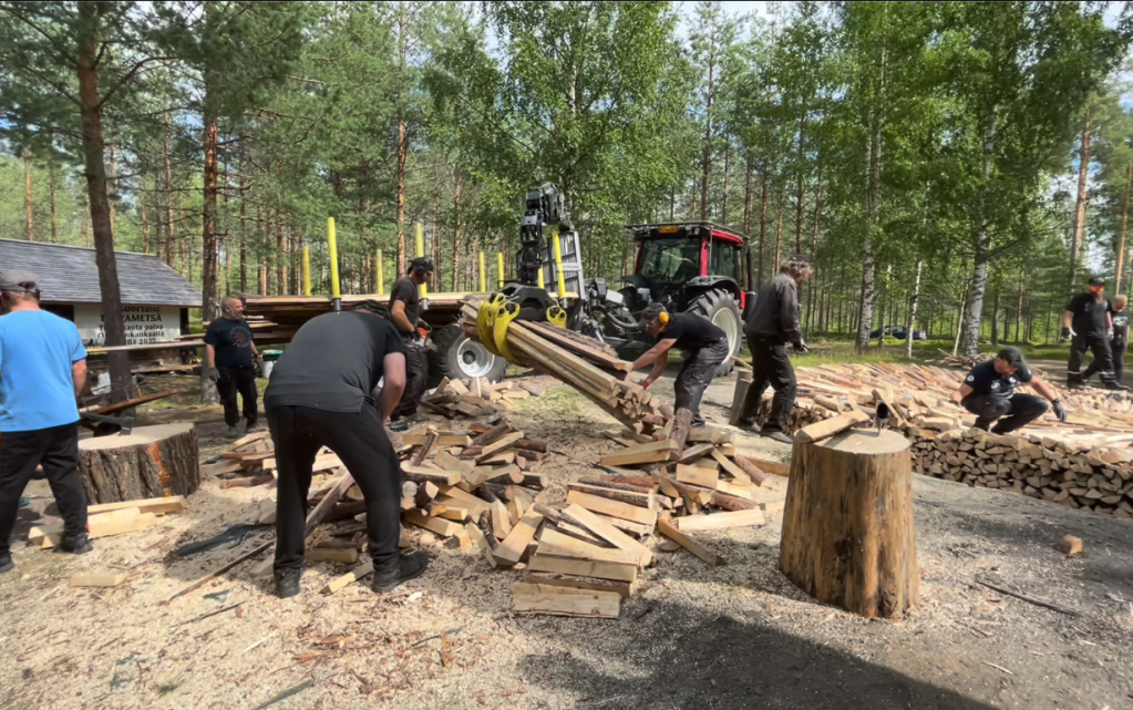 A group of men with various tools, chopping wood.